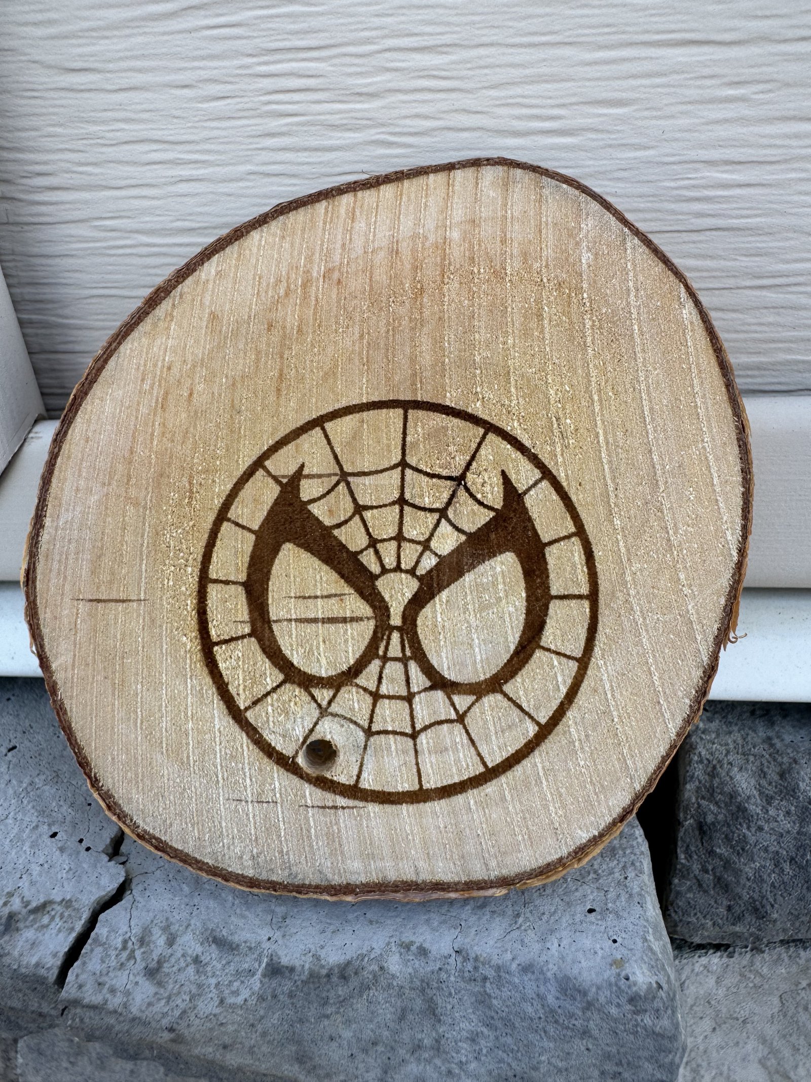 Spider-Man logo laser engraved on wood slice